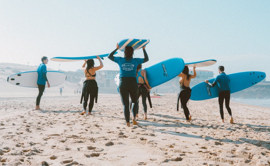 Groupe de surf camp junior aligné sur la plage avec leurs planches