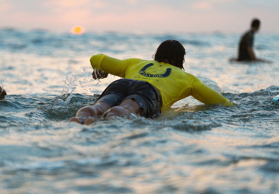 Surfeur au coucher du soleil sur la plage de Bayonne, planche sous le bras